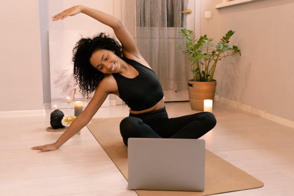 A person comfortably following an online yoga class on their laptop at home